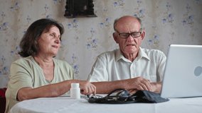elderly married couple sitting in front of laptop monitor talking online with doctor, old husband and wife together consult with therapist through computer at home