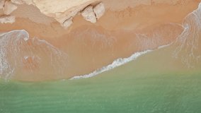 Portugal, Europe. Beautiful sandy beach with low tide as seen from top. Aerial view of people on paddle boards by the shore. High quality 4k footage