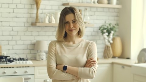 Irony sarcasm emotion blonde girl looking at camera with happy smile. Young adult 30s woman pretty face portrait. Ironic emotional positive person at kitchen. Natural beauaty lips. Happinest hosewife