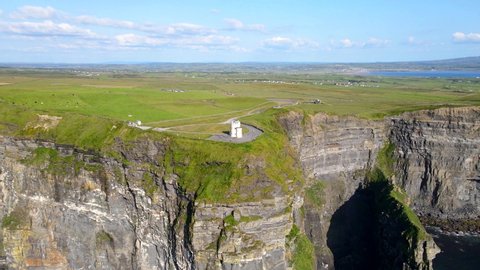 Aerial view over the beautiful Cliffs of Moher off the west coast of Ireland. Clear sunny sky, O'Brien's tower and spectacular sea stack is visible in the background.