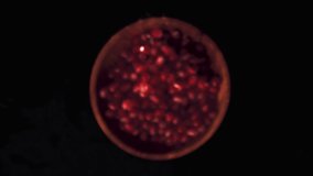 Super slow motion of the grain of ripe pomegranate in a wooden plate. On a black background. Filmed on a high-speed camera at 1000 fps. High quality FullHD footage