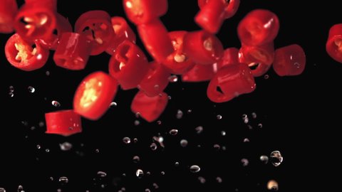 Super slow motion chopped chilli pepper with water droplets. On a black background.Filmed on a high-speed camera at 1000 fps. High quality FullHD footage