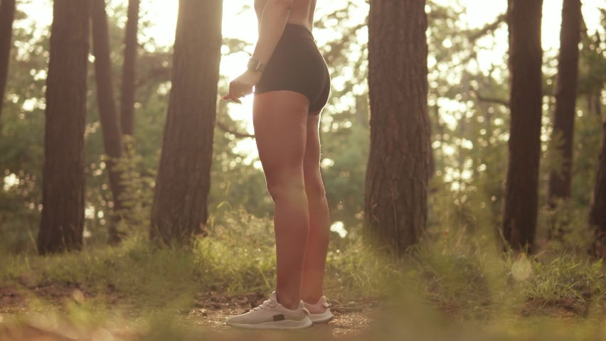 Young woman doing squats outdoors