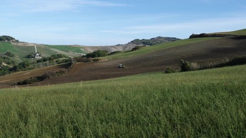 Tractors at work in the fields of the Montefeltro hills in the Marche region of Italy