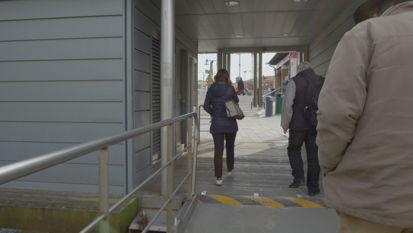 Exit the landing stage after getting off the Vaporetto to arrive in Piazzale Roma.