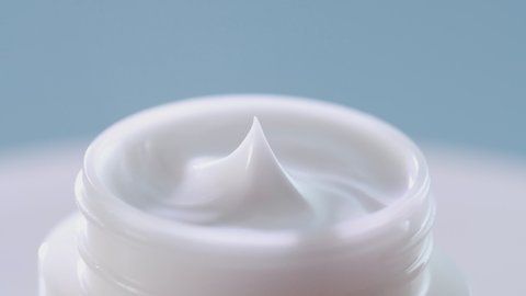 A close-up fo woman finger touching face cream 
