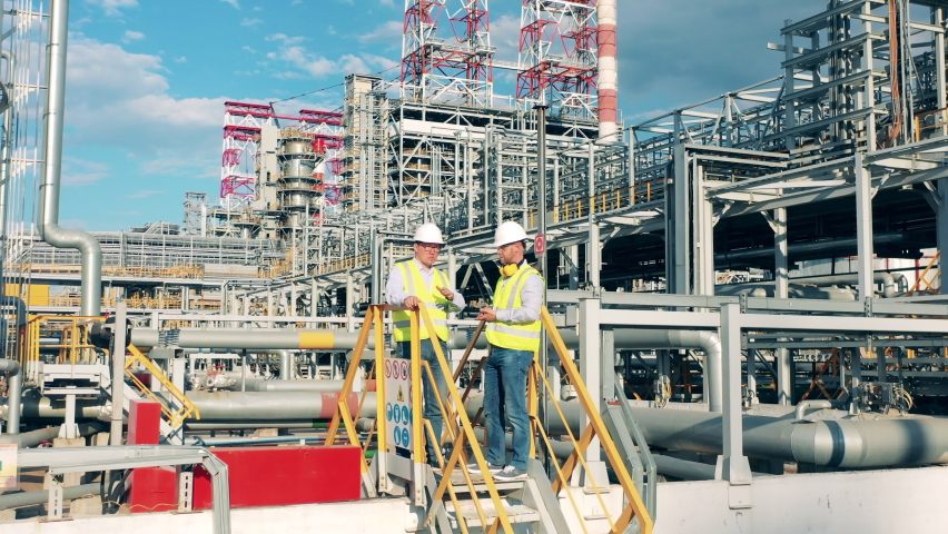 Workers are planning a project on the premises of the oil refinery Royalty-Free Stock Footage #1077021734