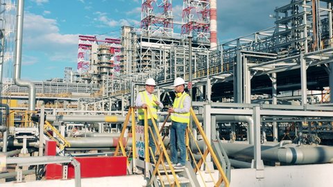 Workers are planning a project on the premises of the oil refinery