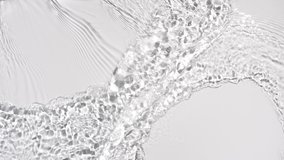 Water flows from opposite sides creating waves, ripples and concentric circles on pale grey background | Background shot for skin care cosmetics with hyaluronic acid commercial - Powered by Shutterstock - Get 15% off with code: PIKWIZARD15
