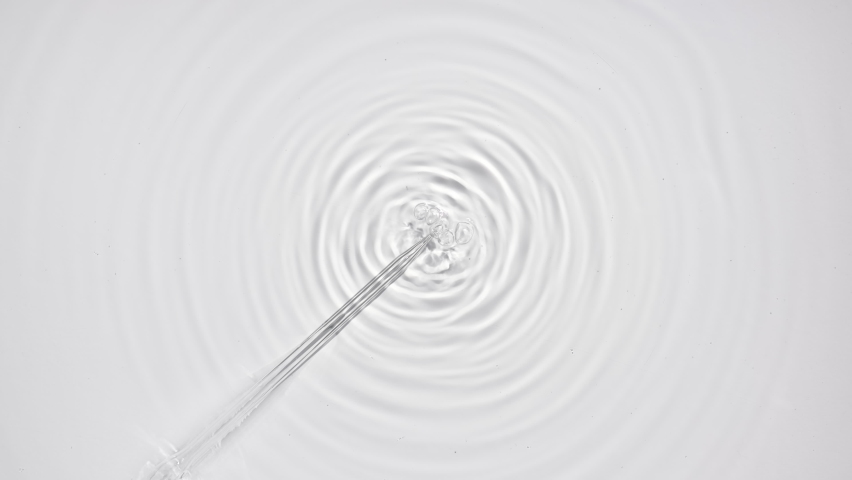 Liquid is injected from syringe creating bubbles and circles on water surface on pale grey background | Macro shot of skin care cosmetics ingredients for its commercial - Powered by Shutterstock - Get 15% off with code: PIKWIZARD15