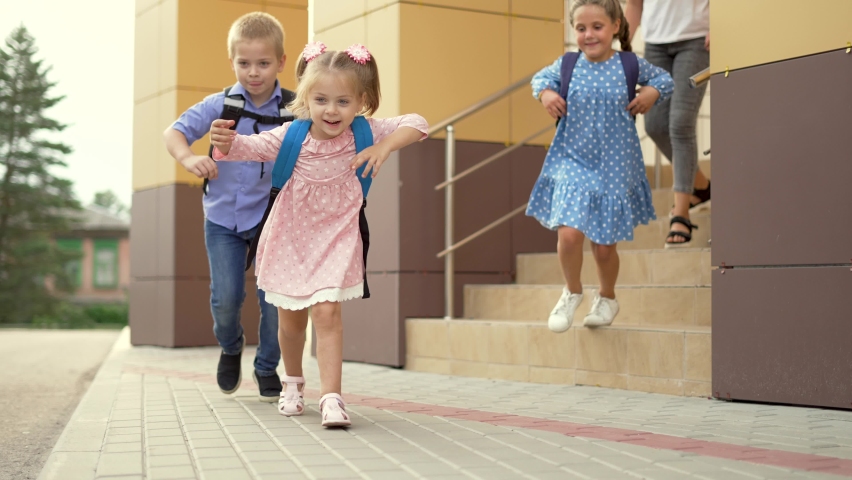 Child run to school with backpack. Back to school. Happy child run with backpack. School education. Child learning after lockdown. Happy family run through schoolyard. Joy of learning. Child to school Royalty-Free Stock Footage #1077030983