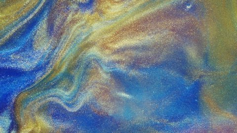 Fluid art. Liquid abstractions. Starry gold dust. Abstract bright red and light pastel streams with gold dust spread across the plane on a blue background. Marble texture.