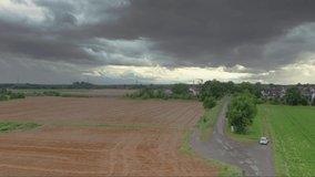 Drone video of Dornheim settlement in southern Hesse with passing high-speed train during approaching thunderstorm during daytime