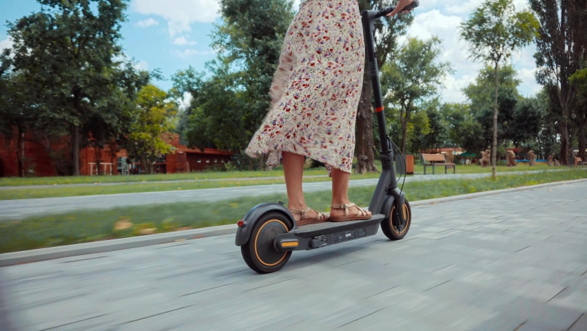 Driving Ecology Transportation.Woman Ride On Electric Scooter Mobility.E-Scooter Rider Rent Personal Eco Transport.Female Drive Electric Scooter In City.Urban Style Riding Ecological Transport Travel. Royalty-Free Stock Footage #1077047297