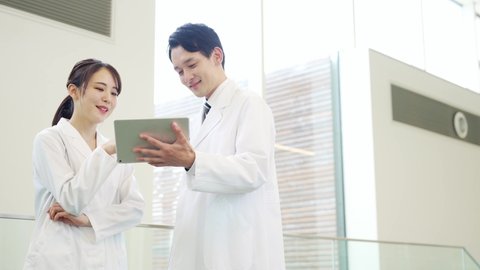 Couple of asian doctor using a tablet pc.