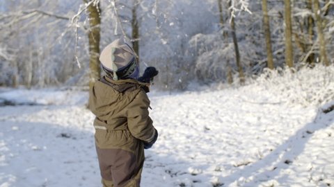 Child joyfully plays in the winter snow at sunset. Slow-motion shot shaking the snow from tree branches. Filmed in 10bit ProRes at 200fps. Lens 35mm Cine Prime. #Shot List APAC August