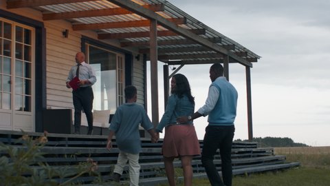 TRACKING Real estate agent showing African American family of three, husband wife and son, a beautiful country house. Shot with 2x anamorphic lens