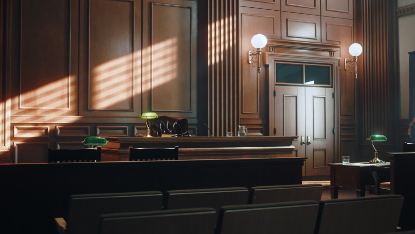 Empty American Style Courtroom. Supreme Court of Law and Justice Trial Stand. Courthouse Before Civil Case Hearing Starts. Grand Wooden Interior with Judge's Bench, Defendant's and Plaintiff's Tables. Royalty-Free Stock Footage #1077064571