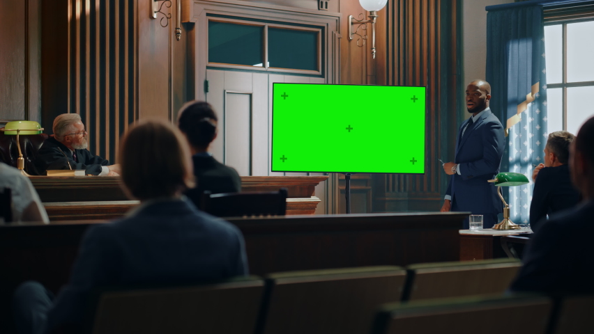 Court of Law Trial in Session: Portrait of Charismatic Male Public Defender Showing Evidence on Green Screen TV Display to Judge and Jury. Attorney Lawyer Protecting Client, Presenting Case. Royalty-Free Stock Footage #1077064661