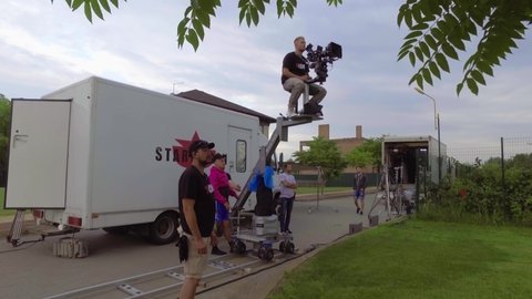 Movie Filming backstage. Behind the scenes of the filming process. Professional cinema production. The cameraman sits in a chair on a high camera crane. Filming staff.
July 30, 2018, Kyiv, Ukraine