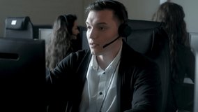 Operator is young man working in call center for VIP customer service. agent puts on headset looks at monitor and helps clients. Service and online security with support of dispatcher from the office - Powered by Shutterstock - Get 15% off with code: PIKWIZARD15