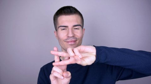 Smiling man shows hashtag sign with his fingers