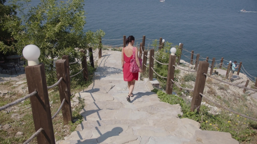girl going down the stairs by the sea