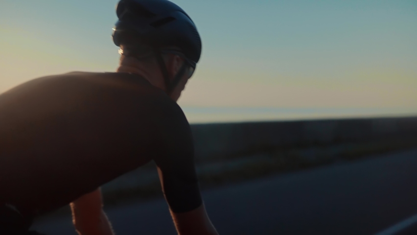 Sport Recreation Bike Cycling On Sunset Time. Cyclist In Helmet Riding On Sunset.Triathlon Time Trial Bicycle.Triathlete Training Endurance Cycling Race.Fit Cyclist Cardio Workout On Triathlon Bike Royalty-Free Stock Footage #1077099719