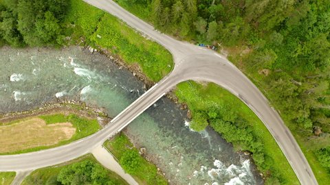 Aerial View Of A Vehicle Driving On A Small Bridge Over Watercourse In Geiranger, More og Romsdal, Norway. top-down static