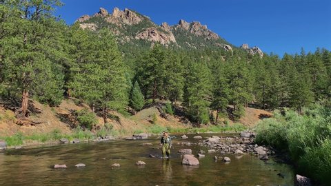 colorado springs , CO , United States - 08 02 2021: Fisherman walking through the platt river outside of Denver Colorado