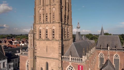 Slow aerial descend showing tower and ship of Walburgiskerk cathedral in medieval Hanseatic town of Zutphen in The Netherlands. Dutch cultural heritage architecture.