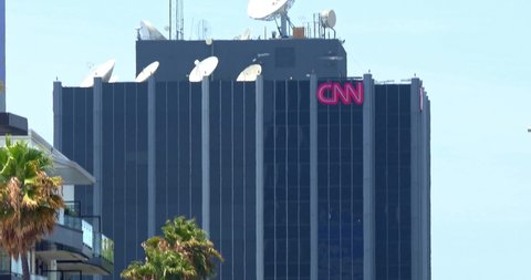 LOS ANGELES, CALIFORNIA, USA - JULY 25, 2021: Rush hour traffic and CNN communication broadcast tower and satellite antennas broadcasting breaking news on Sunset Boulevard in Los Angeles, California, 