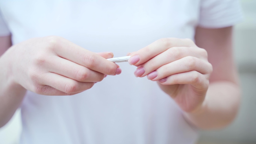 female hands close up breaking a cigarette. Stop no smoking quit smoking concept. Closeup woman holding crushing or destroying cigarettes  Royalty-Free Stock Footage #1077106370