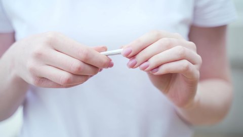 female hands close up breaking a cigarette. Stop no smoking quit smoking concept. Closeup woman holding crushing or destroying cigarettes 