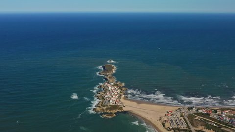 Baleal, Portugal, Europe. Aerial footage of stretching sandy beach with roads and houses along. Picturesque bluish ocean view as seen from above. High quality 4k footage