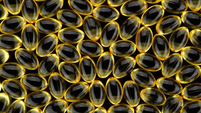 Golden softgel capsules. Omega 3 gold oil capsules top view, Sliding shot. Supplement organic vitamins in softgel capsules. Dietary supplement. 4K UHD video