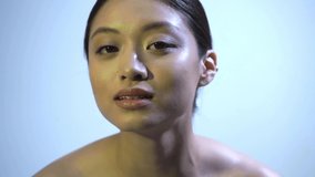 young asian woman with bare shoulders on blue