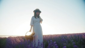 Happy young woman in anticipation of baby, in the summer at sunset walks through beautiful blooming lavender field and enjoys nature. France, Provence, summer, motherhood. Slow motion 4K video