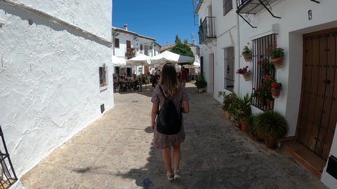 Grazalema, Spain, August 3, 2021: Woman walking through Grazalema streets in Cadiz, Spain. A white village that is a travel destination for many tourists travelling to Andalusia. 