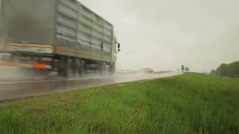 The movement of trucks of trucks with a semi-trailer and cars on a wet road in rain and fog and in poor visibility. Road safety concept. Copy space for text, transportation