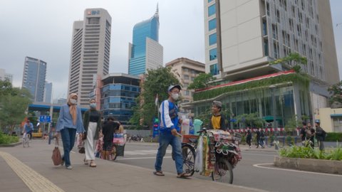 Jakarta, Indonesia - August 1, 2021: Timelapse of People activity  around BNI City Railway Station in the afternoon. Flat color profile