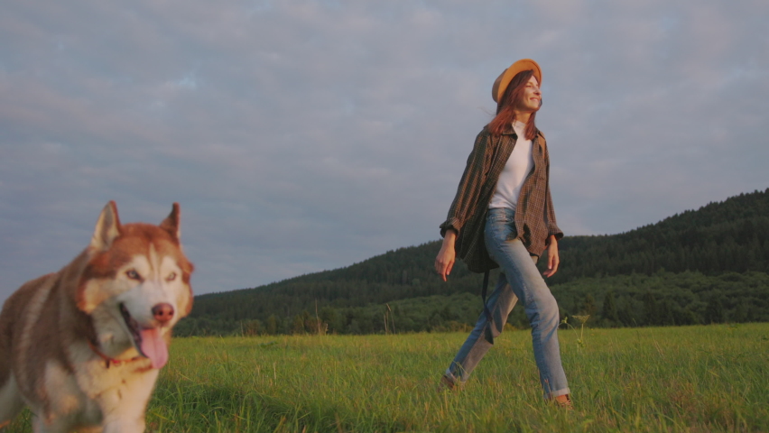 Happy young caucasian woman with Siberian husky dog in beautiful summer landscape. Family vacation with pets. Concept inspiration, nature and adventures. Royalty-Free Stock Footage #1077144314