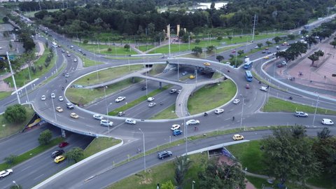 Oribital flight with drone over a roundabout bridge located to the west of the city, with a pedestrian crossing and a bike path to the Simon Bolivar and Salitre parks in Bogota.