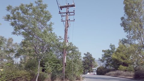 panning view of an old wooden low voltage power line with transformer