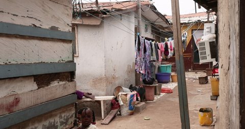NIMA, GHANA - 20 JUL 2021: Poverty home in crowded village Nima Accra Africa clothes drying. Small poverty centered community. Narrow alleys  foot paths in Muslin area of the city. Concrete and tin.