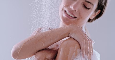 slow motion of a woman taking a shower. beautiful girl enjoying the water drops on body