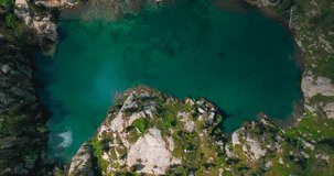 Aerial vertical 4K footage of two lakes in a green natural environment in the Spanish Pyrenees.