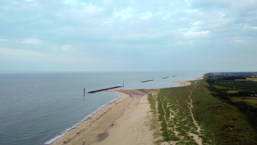 Wide landscape aerial shot flying over an empty British beach in Norfolk Royalty-Free Stock Footage #1077154196
