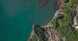 Aerial vertical 4K footage of a blue lake in a green natural environment in the spanish Pyrenees.