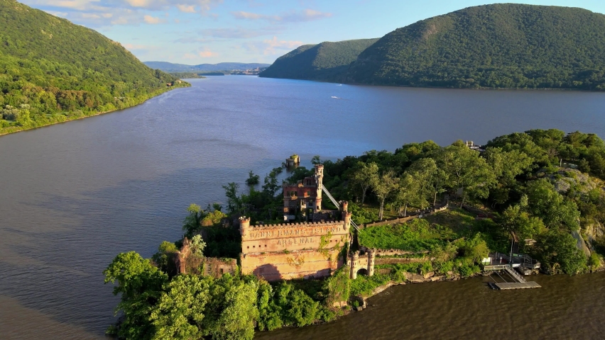 Aerial drone footage of an abandoned castle on a small island. This is Bannerman's castle on Pollepel island in New York's Hudson River Valley during summer in America. Royalty-Free Stock Footage #1077155501